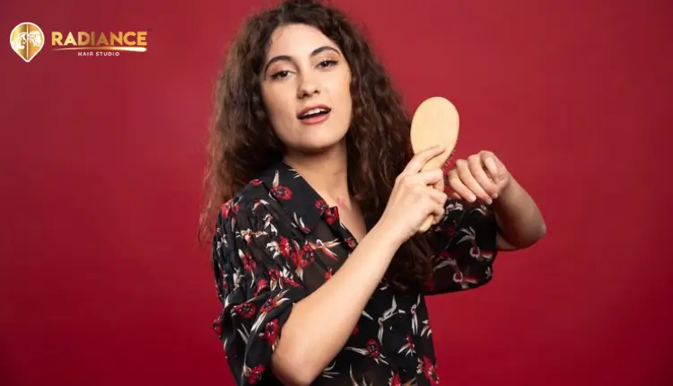 Girl styling her hair wig using a comb
